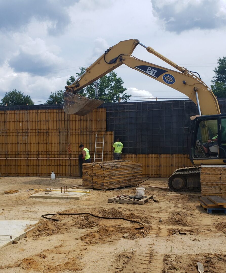 Excavator and workers at construction site.