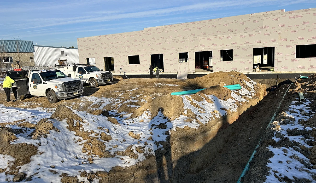 Construction site with trucks and building exterior.